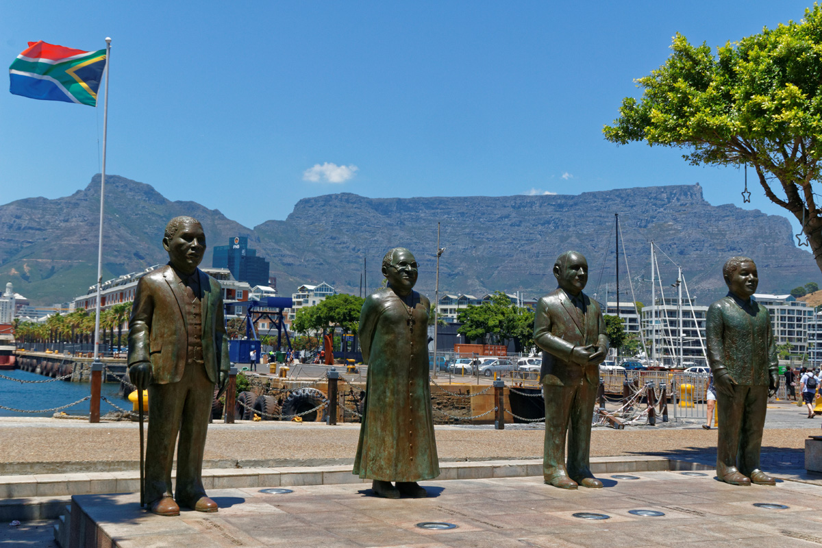 Statuen der vier südafrikanischen Friedensnobelpreisträger am Nobel Square in Kapstadt. Von links nach rechts: Albert Luthuli (Friedensnobelpreis 1960), Desmond Tutu (1984), Frederik Willem de Klerk und Nelson Mandela (beide 1994). Foto: Erik Koole Photography / Shutterstock.com